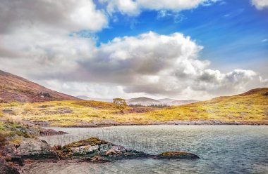 Güneşli su ve kümülüs bulutları county Kerry ile bahar manzara. İrlanda.