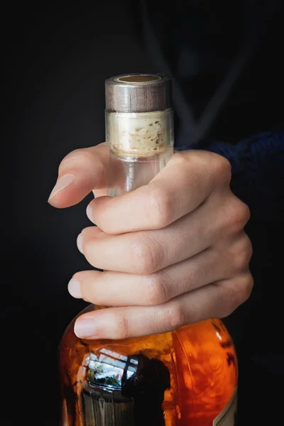 Womas hand håller en flaska med alkoholhaltig dryck — Stockfoto