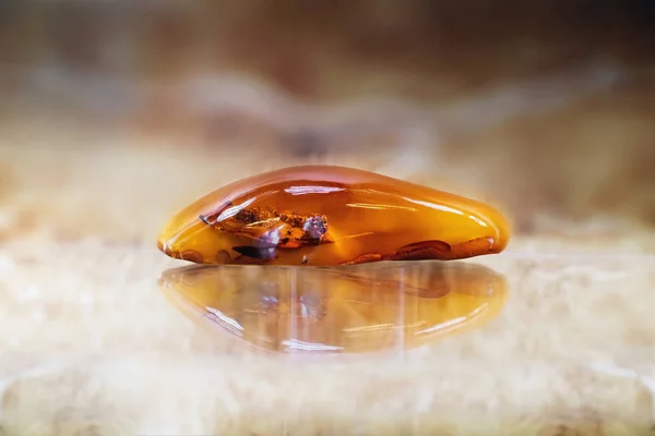 Pezzo di ambra in uno sfondo sfocato — Foto Stock
