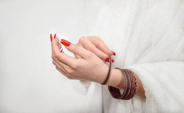 Beyaz arka planda bileziklere sahip kadın elleri