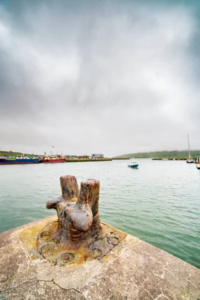 Oude roestige metalen Bolder en schepen in de haven van Dingle bij wazig — Stockfoto