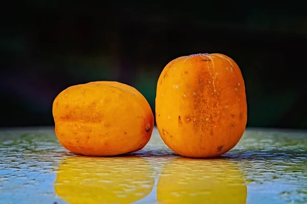 Two ripe True Lemon cucumbers on a wet surface — Stock Photo, Image