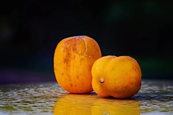 Two ripe True Lemon cucumbers on a wet surface — Stock Photo, Image