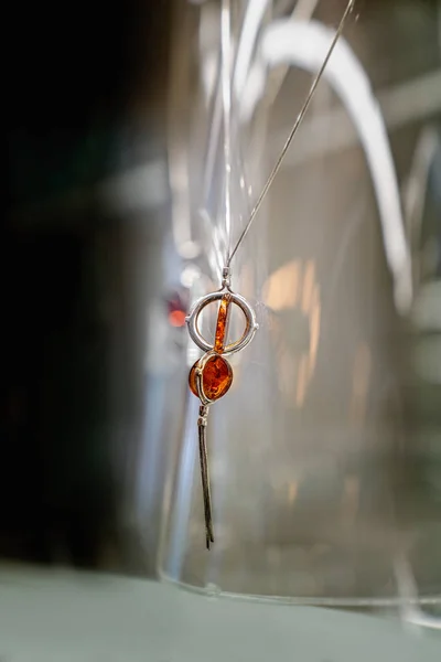 Kalung perak dengan amber di rak kaca — Stok Foto