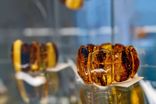 Янтарные браслеты на стеклянной полке — стоковое фото