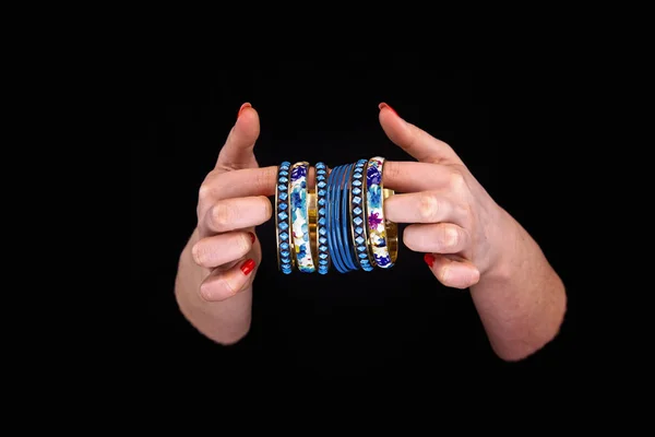 Mãos de mulher com pulseiras azuis douradas . — Fotografia de Stock