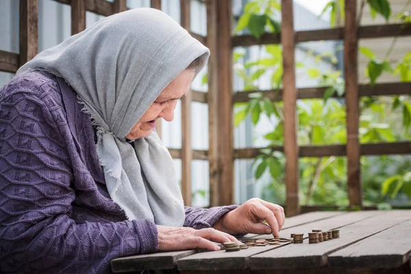 Money, coins, retired grandmother and the concept of a living wage - the Old woman sadly finds little money