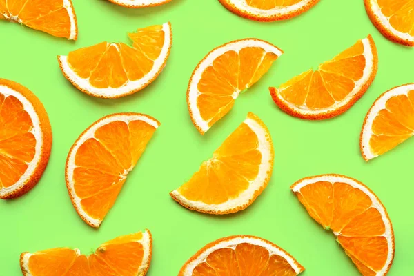 Fruit pattern of fresh orange slices on green background.