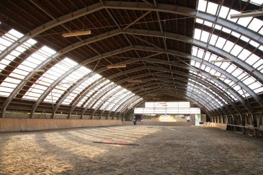 Empty riding hall  building interior without people ready for equestrian training wintertime clipart