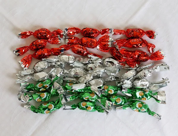Dulzura navideña acariciada en colorido envoltorio metálico en colores nacionales húngaros —  Fotos de Stock