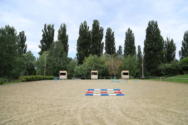 空のトレーニングフィールド上の極のイメージ 馬のための木製の障壁を背景として 馬術障害物のカラフルな写真 乗馬訓練のための空のフィールド — ストック写真