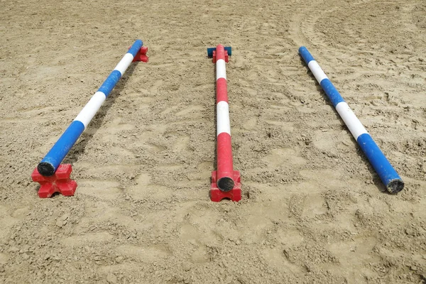 Image of poles on empty training field. Wooden barriers for horses as a background. Colorful photo of equestrian obstacles. Empty field for equestrian training