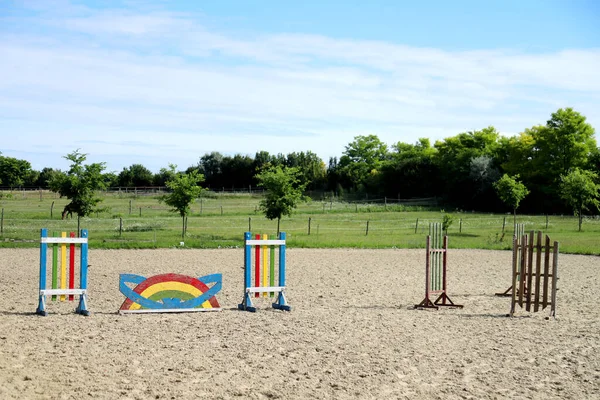 空のトレーニングフィールド上の極のイメージ 馬のための木製の障壁を背景として 馬術障害物のカラフルな写真 乗馬訓練のための空のフィールド — ストック写真