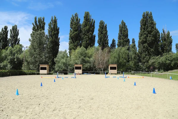 Image of poles on empty training field. Wooden barriers for horses as a background. Colorful photo of equestrian obstacles. Empty field for equestrian training