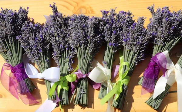 Bouquet of lavender tied with violet ribbon. Fresh lavender flower bouquet on old rustic wooden table. Purple herbal flower blossom. Lavender aromatherapy