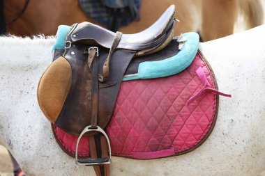 Bir atın sırtında üzengiyle eyer. Spor bir ata yaklaş. At terbiyecisi. Binicilik sporu etkinliği