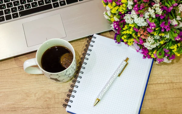 Ofis masası manzaralı. defter, çiçek, kalem ve elma ahşap masada..