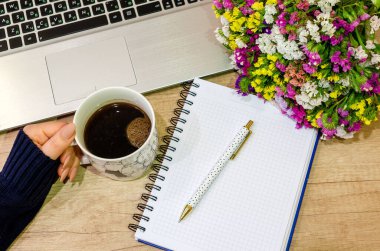 Ofis masası manzaralı. Ahşap masa, bilgisayar, defter, çiçek, kalem ve elma..