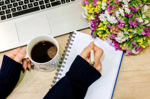 Ofis masası manzaralı. Ahşap masa, bilgisayar, defter, çiçek, kalem ve elma..