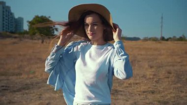 Açık havada şapka portresi yapan genç bir kadın. Yüksek kaliteli FullHD görüntüler