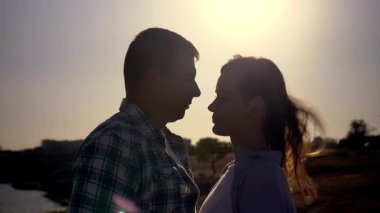 Gün batımında birbirlerine bakan genç bir çiftin siluet portresi. Romantik yavaş çekim doğadaki aşkı, samimiyeti ve duygusal bağı yakalar.. 