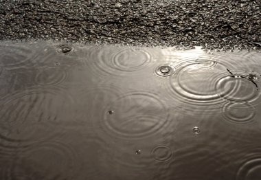 Yağmur bir su birikintisi ve Tarmac Drops