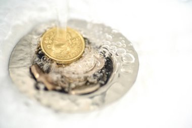 Su lavabo drenajı sikke üzerinde akan