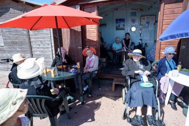 Clacton Beach Hut tarafından oturan rahatlatıcı insanlar