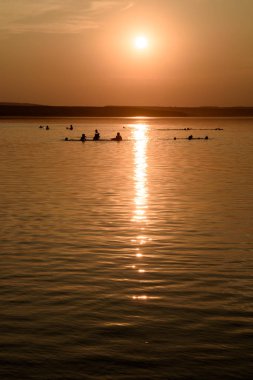 Sunset 'te bir gölde yüzerken insanlar
