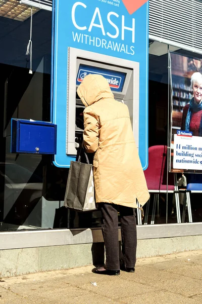 Bir ATM Cashpoint makinesi kullanarak kadın emeklinin — Stok fotoğraf