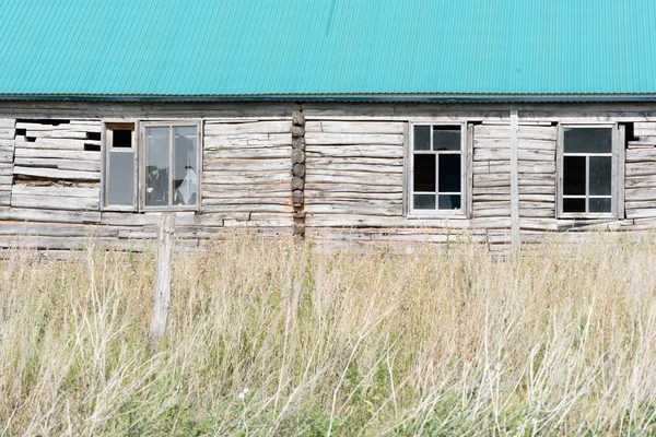 Casa de madera abandonada con ventanas rotas — Foto de Stock