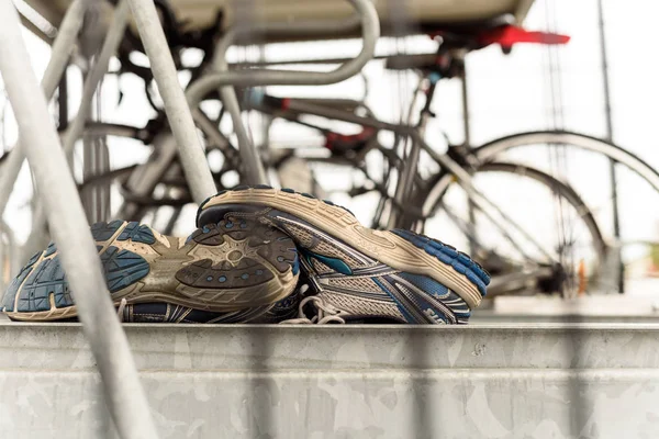 Hardloopschoenen en geparkeerde forensen fiets — Stockfoto