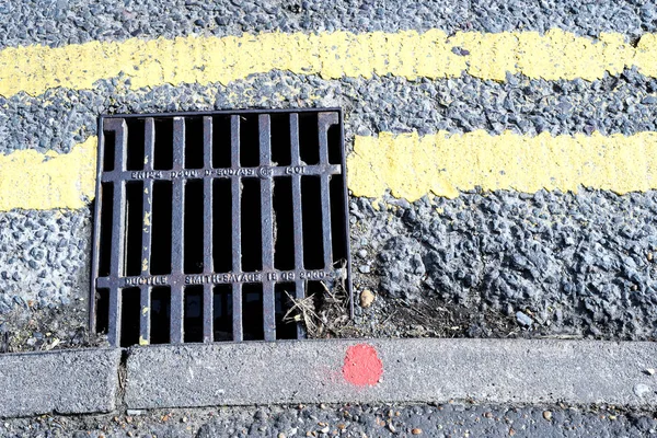 Storm Drain Grill and Double Yellow Painted Lines — Stock Photo, Image