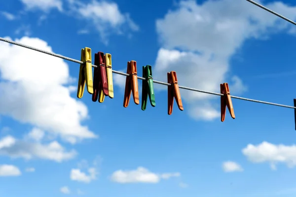 Diverse heldere plastic kleren pinnen op een waslijn — Stockfoto