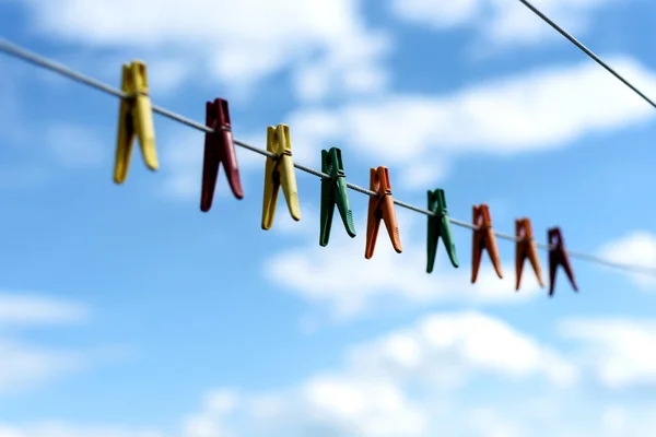 Diverse heldere plastic kleren pinnen op een waslijn — Stockfoto