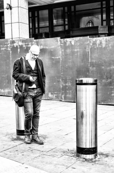 Человек с телефоном в ожидании черного и белого — стоковое фото