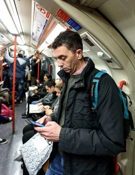 Man met behulp van smartphone op London Underground Tube — Stockfoto