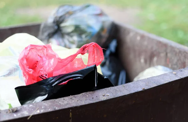 Пластиковые пакеты для мусора в металлическом контейнере на открытом воздухе — стоковое фото