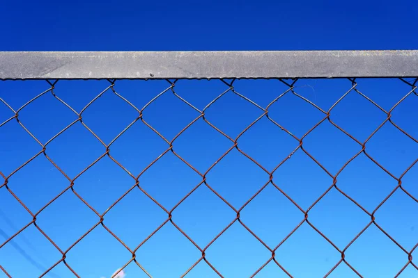 Valla de enlace de cadena de malla de alambre y cielo azul — Foto de Stock