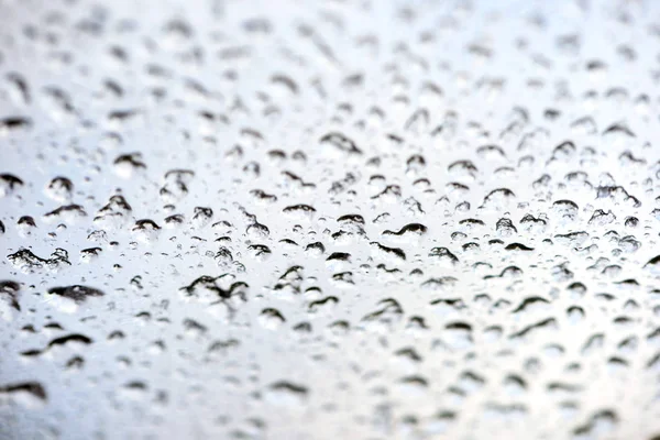 Água da chuva cai em uma janela de vidro — Fotografia de Stock