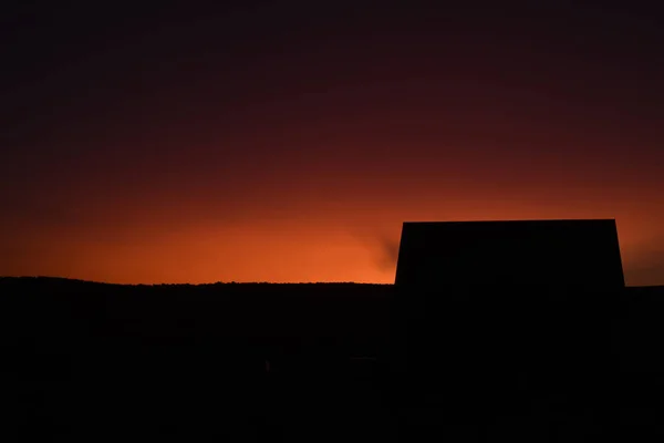 Ljust apelsin himmel och Silhouette byggnad — Stockfoto