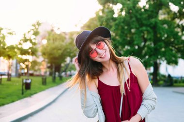 yaz moda stil, sokakta yürüyen kadın turist Europe.Happy kadın için güneş gözlüğü içinde seyahat ve açık havada yürüyüş elbise. Kameraya bakarak