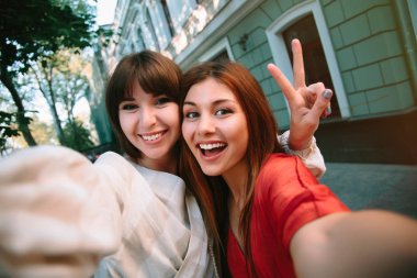Yaşam tarzı selfie eğleniyor ve yapma selfie, Genç hipster trendy kıyafetler ve güneş gözlüğü, uzun tüyleri, taze makyaj iki genç pozitif kadın portresi kapatın. mutlu birlikte. kız kardeşler, arkadaşlar