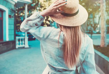 Kadın moda kavramı. Sokakta yürüyen genç güzel moda bayan açık portresi. Modeli şık şapka ve kıyafet giyiyor. Güneşli bir gün. Arkadan görünüm. Belden yukarı. Metin için yer kopyalayın
