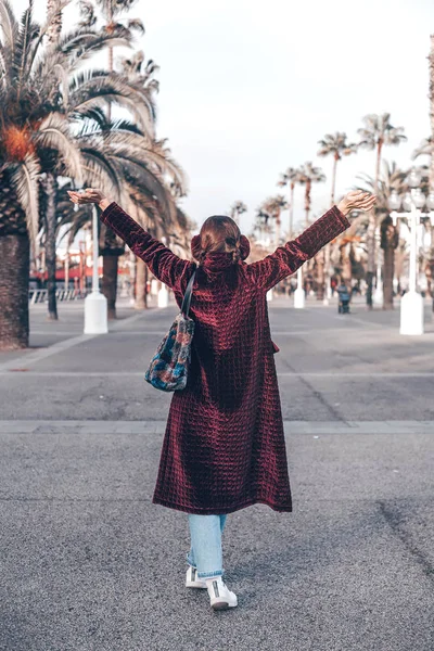 模擬を長い退屈ジャケット バッグ 都市景観 イヤーマフを着用を手でビュー流行に敏感な女の子をバックアップします 都市の背景に旅行 手を上げた 観光客 バルセロナのリラックス ライフ スタイル — ストック写真