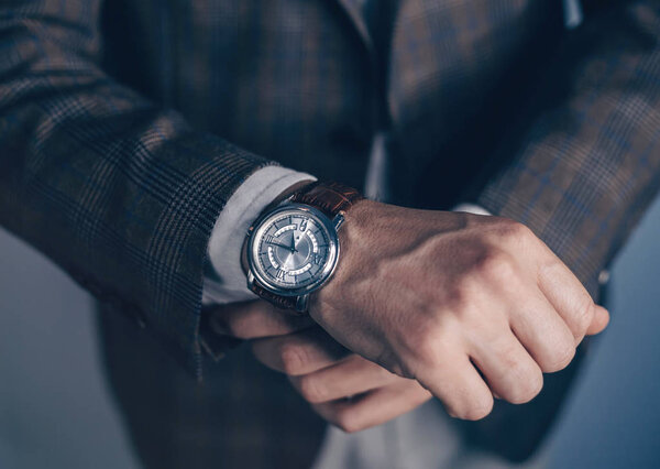 Vintage smart casual outfit outdoor.Fashion model man posing in office.Suited man posing.closeup fashion image of luxury watch on wrist of man.body detail of a business man.Not isolated.