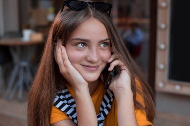 Akıllı telefon kullanan güzel genç hipster kadın. Genç kız moda yaz kafe ve cep telefonu bir şehirde sokak konuşuyor. Smartphone sokakta olan mutlu beyaz kadın