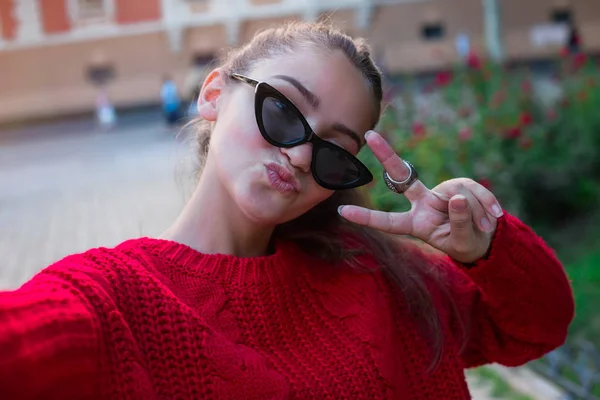 若い女の子ストリート春市に電話で手から Selfie を取る 都市生活のコンセプトです クローズ アップ Selfie 肖像画学生都市で長い髪型とサングラスで魅力的な女の子の — ストック写真