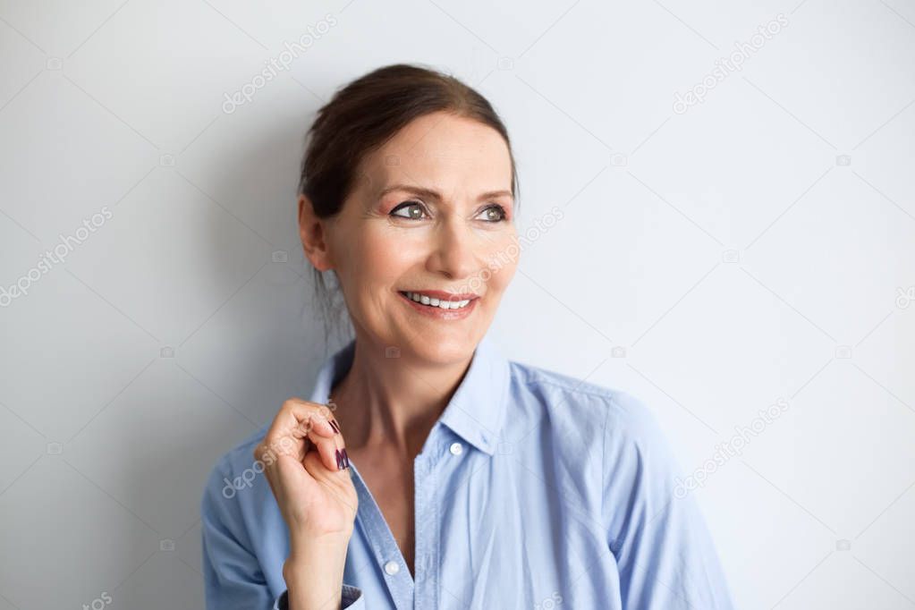Beautiful mature woman smiling.Close up portrait of beautiful older woman smiling and standing by wall.Portrait of business woman with glasses smiling.