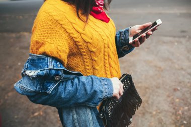 Akıllı telefon kullanan güzel genç hipster kadın. Dışında yürüme ve cep telefonuna kısa mesaj okuma çekici genç kadın portresi